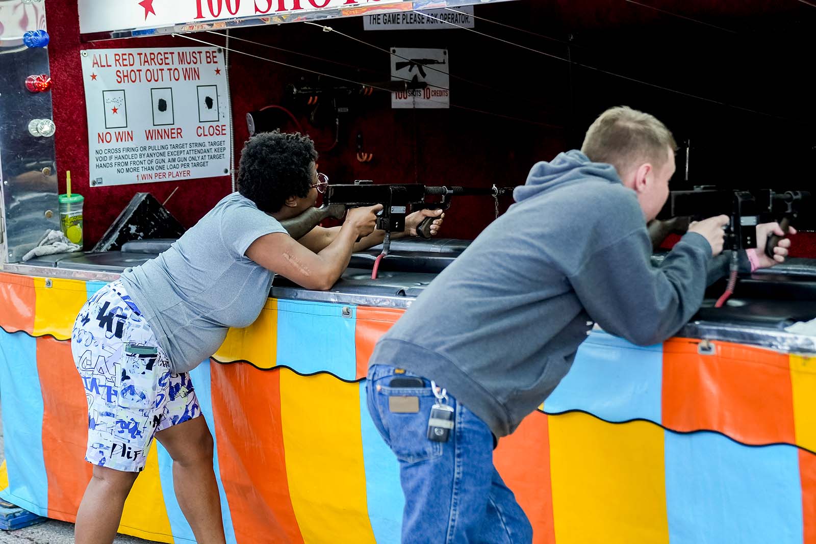 Players aiming at targets in Machine Gun midway game