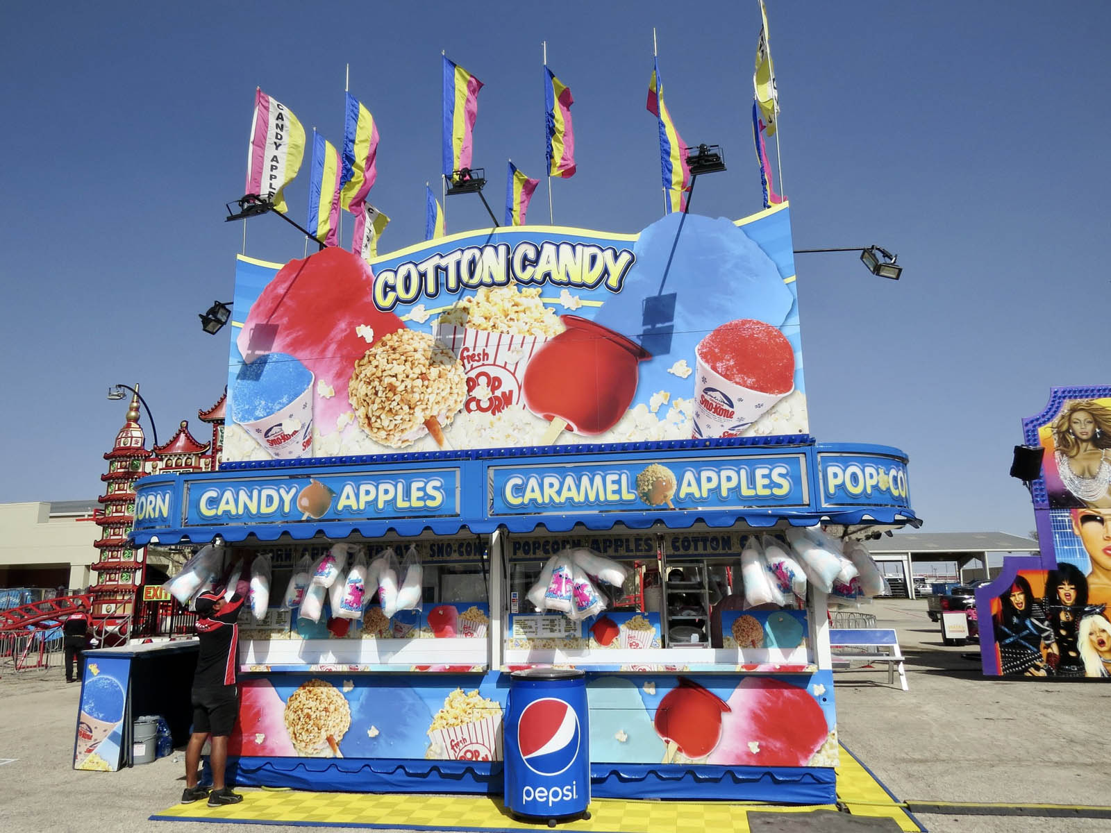 Colorful cotton candy and candy apples at carnival stand