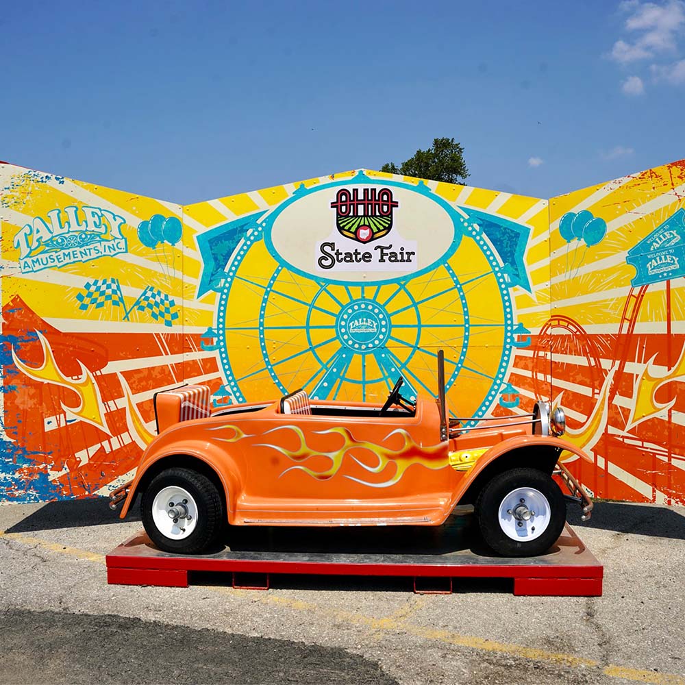 Every midway gets its own decorations with Talley Amusements; this shows a child-sized hot rod on a stand, perfect for photos